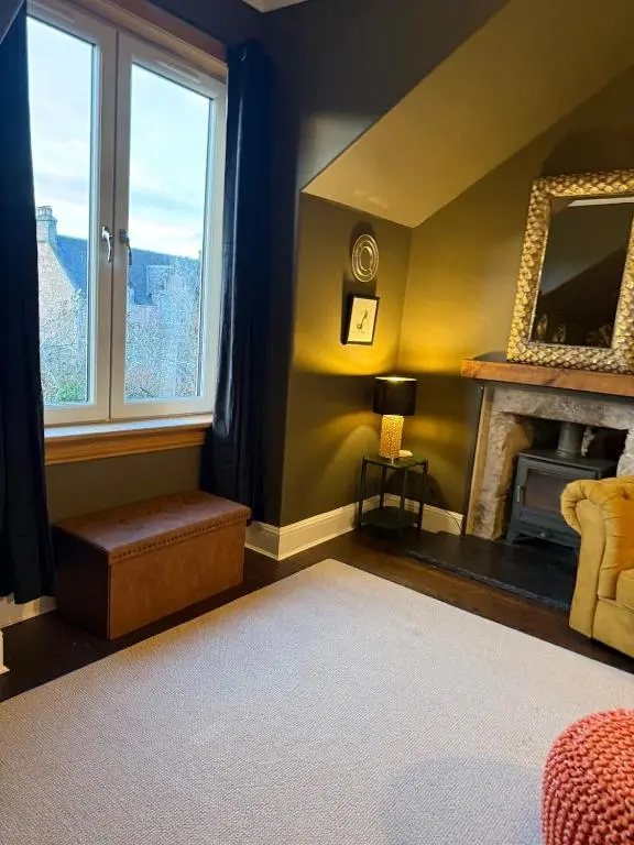 a living room with a fireplace and a mirror at The Yellow Door in Inverness