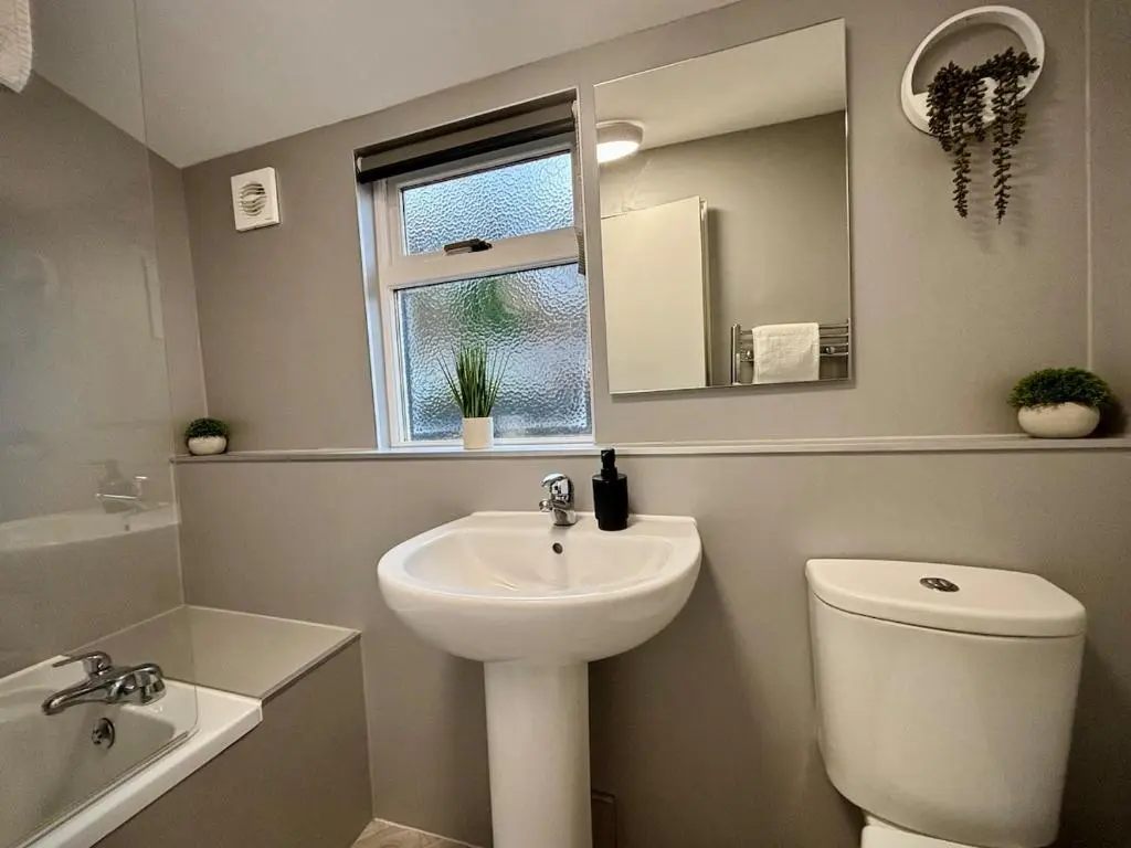 a bathroom with a sink and a toilet and a mirror at Stunning Speyside retreat, ideal for Whisky lovers in Rothes