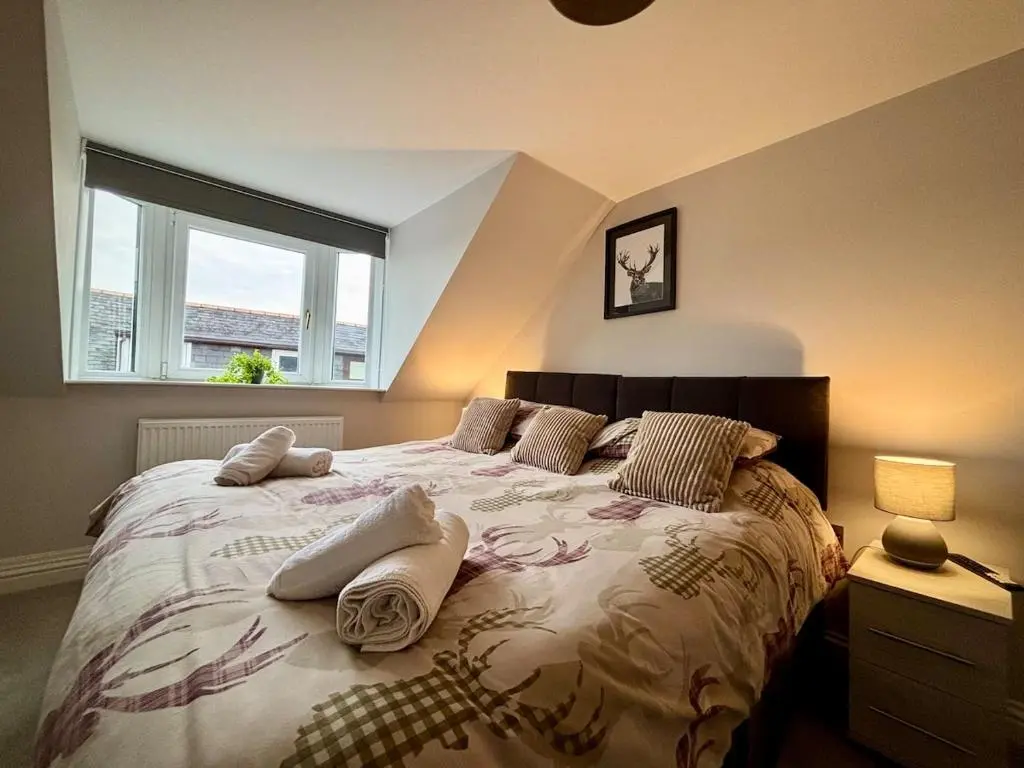 a bedroom with a large bed with pillows and a window at Stunning Speyside retreat, ideal for Whisky lovers in Rothes