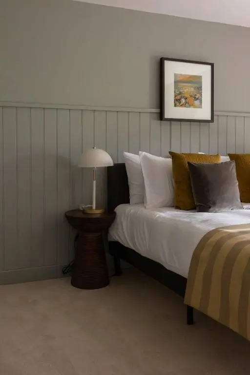 a bedroom with a bed and a table with a lamp at Luxury Farmhouse, near Dornoch