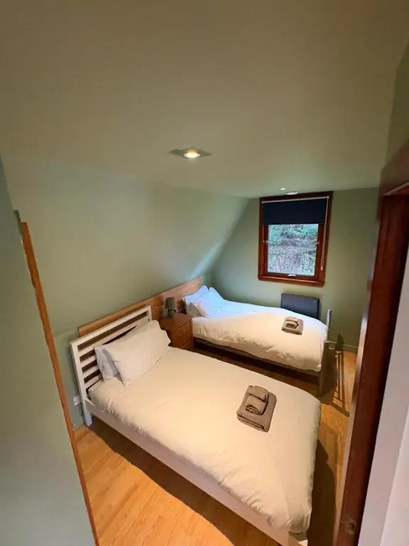 a small room with two beds and a window at The Great Glen Getaway Lodge in Spean Bridge