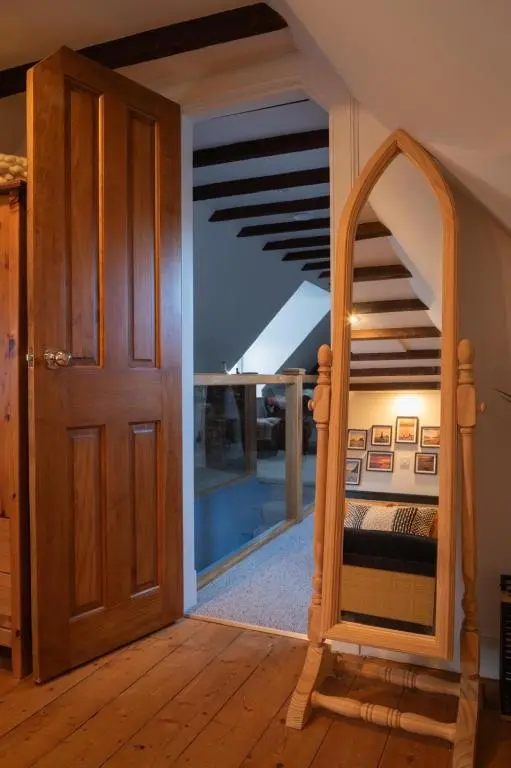 a room with a wooden door and a staircase with a mirror at Sea Crest - Beachfront Escape with Whisky Snug in Cullen