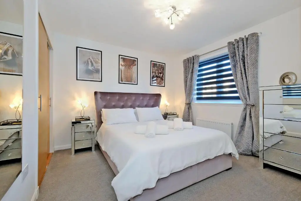 a bedroom with a white bed and a window at A comfortable and modern 2BR 2BA home near ABZ in Inverurie