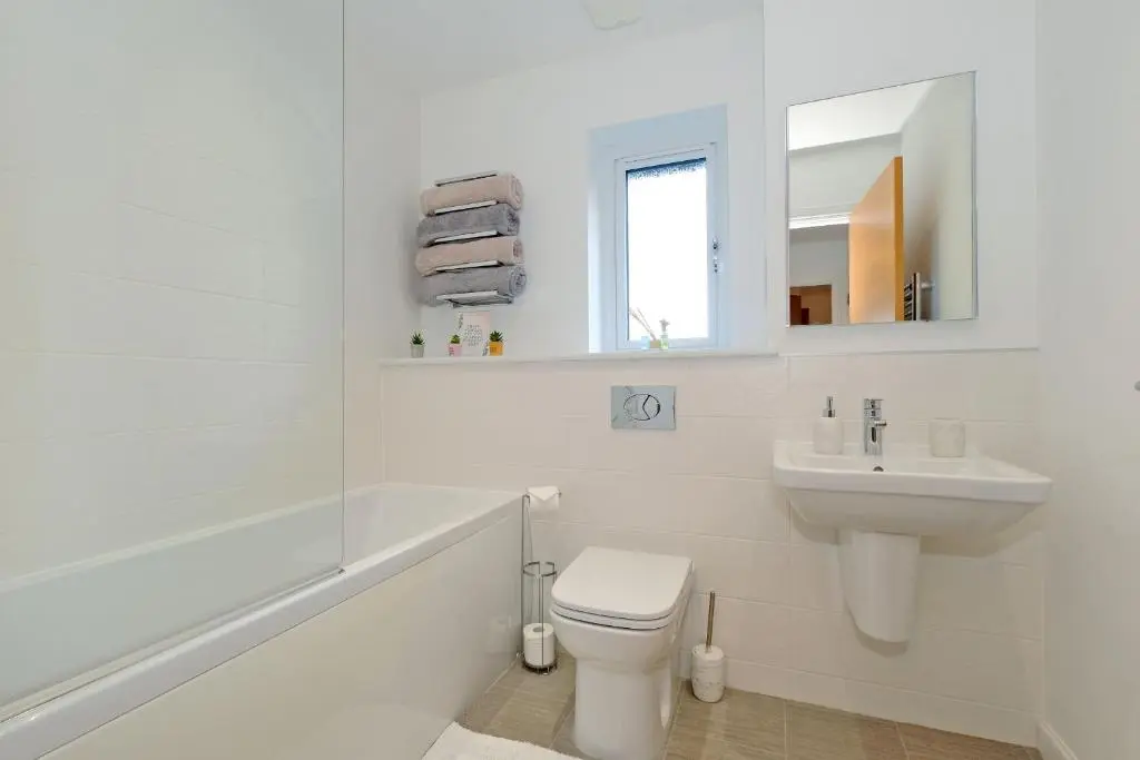 a white bathroom with a toilet and a sink at A comfortable and modern 2BR 2BA home near ABZ in Inverurie