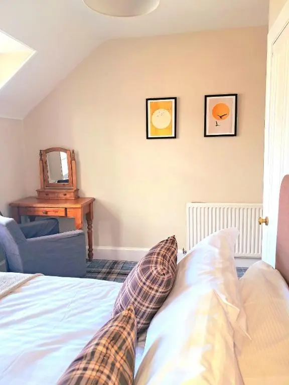 a bedroom with a bed and a table and a mirror at 42 in the Crown in Inverness