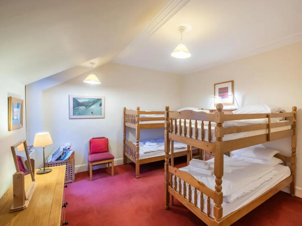 a room with two bunk beds and a chair at Villa Netherwood by Interhome in Newtonmore