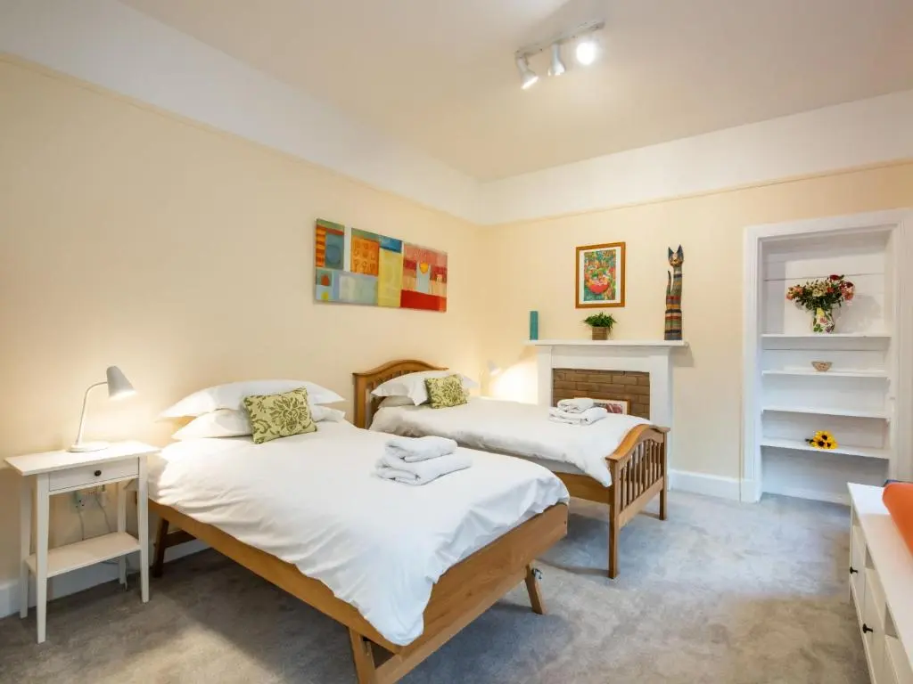 two beds in a room with a fireplace at Villa Netherwood by Interhome in Newtonmore