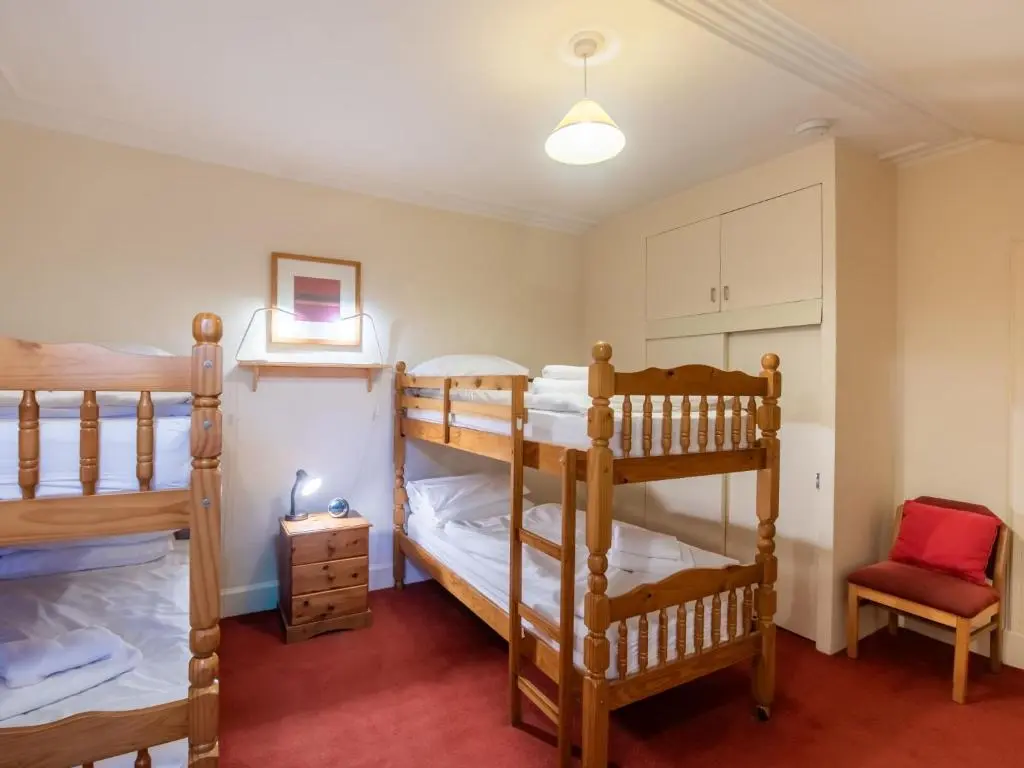 a bedroom with two bunk beds and a chair at Villa Netherwood by Interhome in Newtonmore