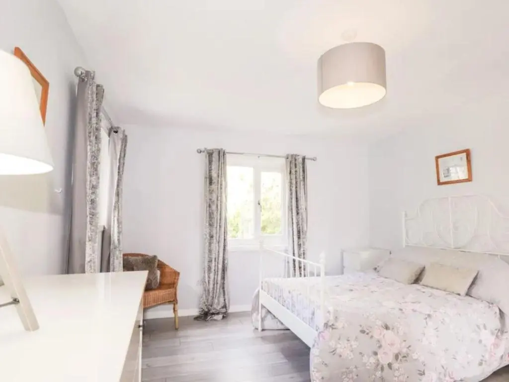 a white bedroom with a bed and a window at Holiday Home Greenaway by Interhome in Skye of Curr