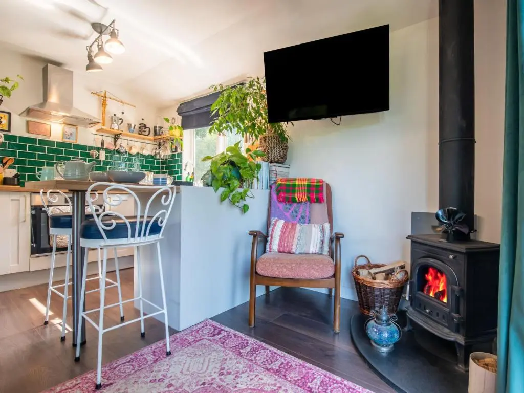 a kitchen with a stove and a table and chairs at Chalet The Cabin by Interhome in Eskadale