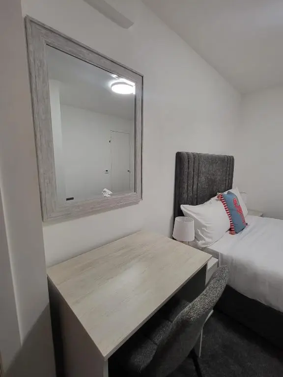 a bedroom with a desk and a bed and a mirror at Harbour Nights Lossiemouth in Lossiemouth