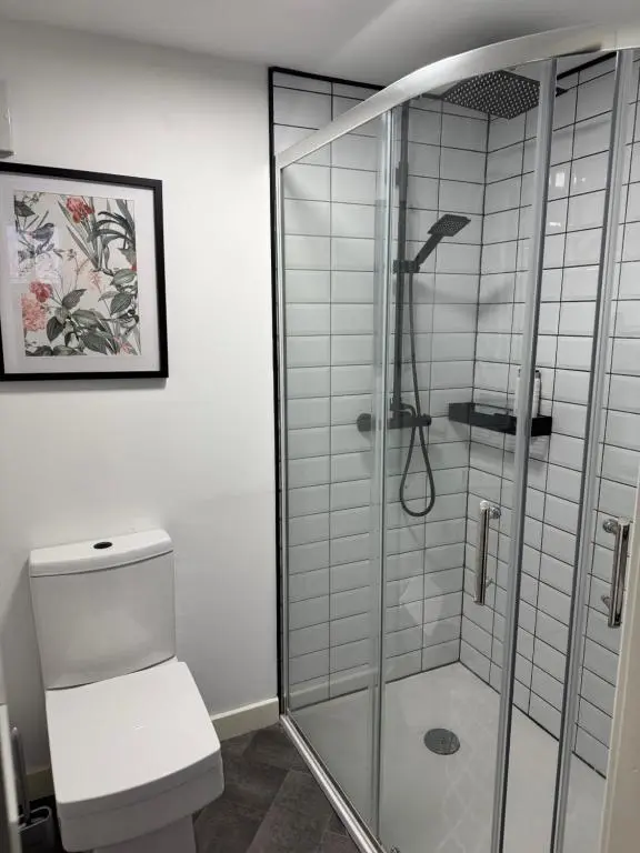 a bathroom with a glass shower with a toilet at Woodlands Banff in Banff