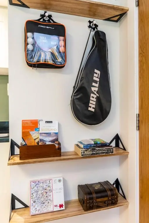 a shelf with a bag and books on it at Calder apartment Raven Wing in Fort Augustus
