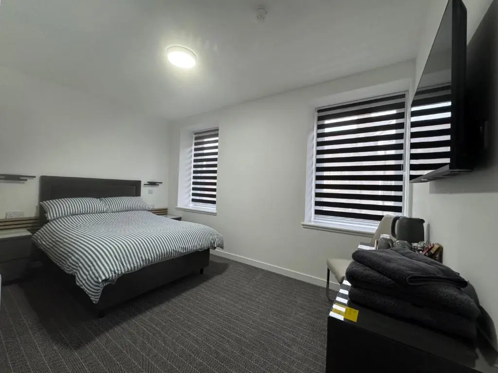 a bedroom with a bed and a television in it at TSB Rooms in Turriff
