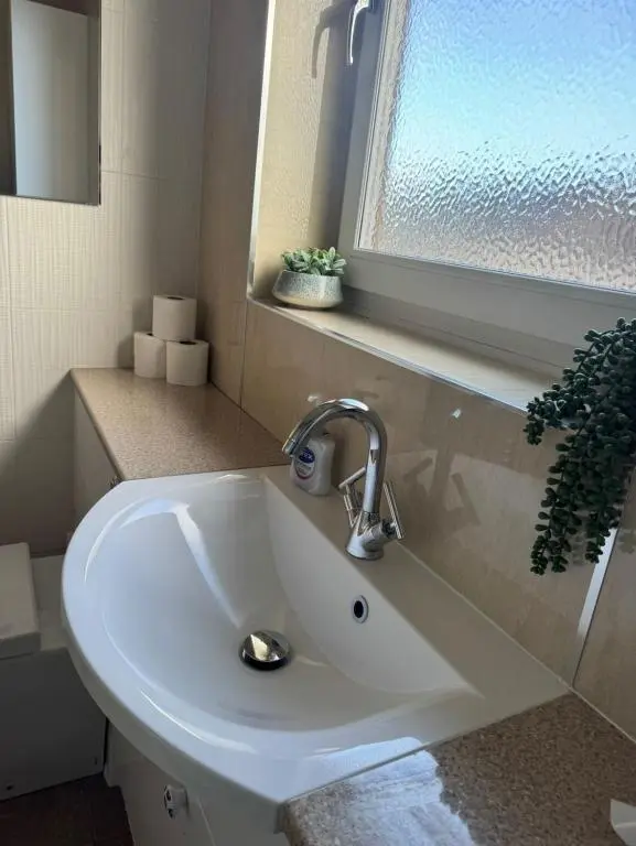 a white sink in a bathroom with a window at Aberdeen Home near City in Aberdeen