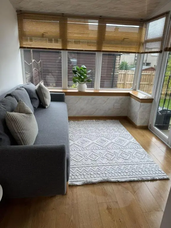a living room with a couch and a large window at Aberdeen Home near City in Aberdeen