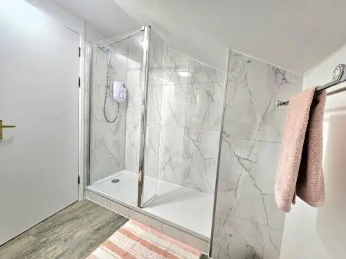 a shower with a glass door in a bathroom at Inverness City Escape! in Inverness