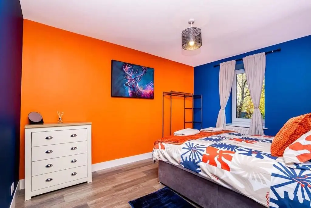 a bedroom with an orange and blue wall at Airport apartment - Aberdeen - Free Parking in Aberdeen