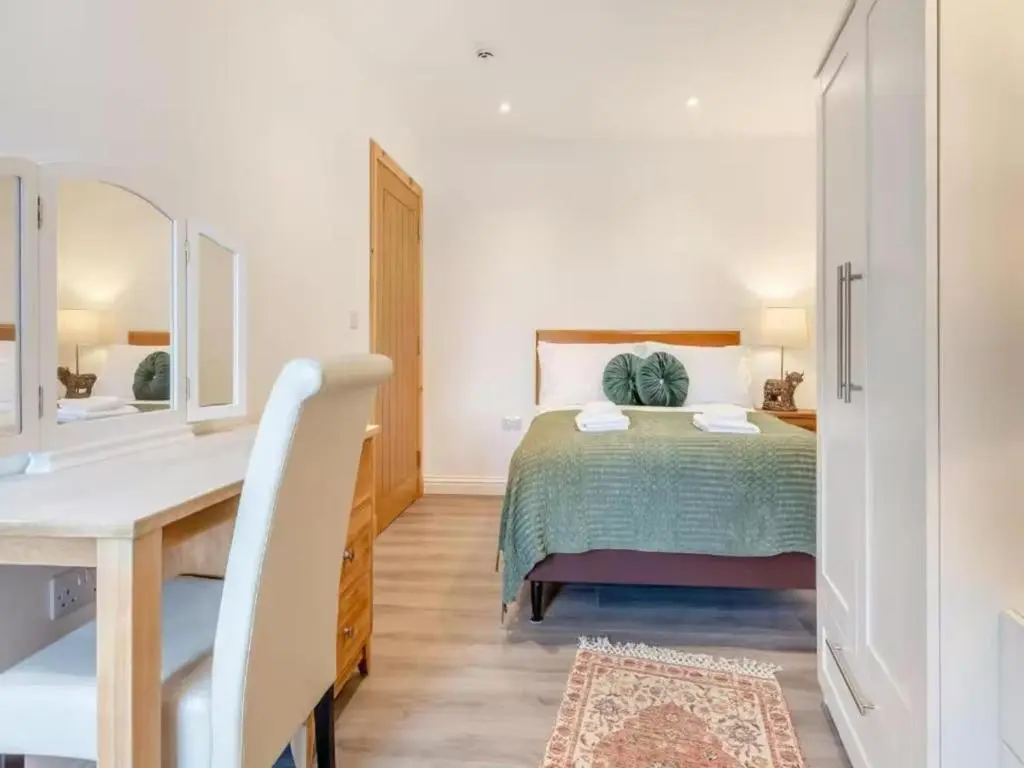 a bedroom with a bed and a desk and a mirror at Family - Central - Wifi - Parking - Sleeps 4 in Inverness