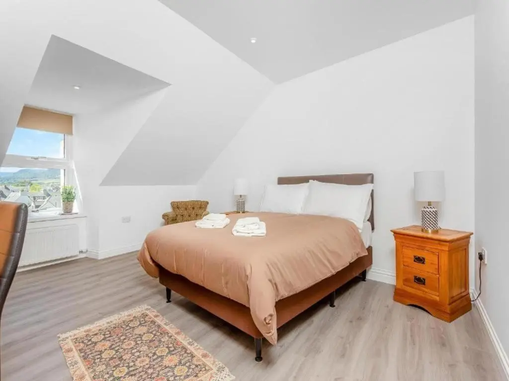 a bedroom with a bed and a table and a window at Family - Central - Parking - Wifi - Sleeps 3 in Inverness