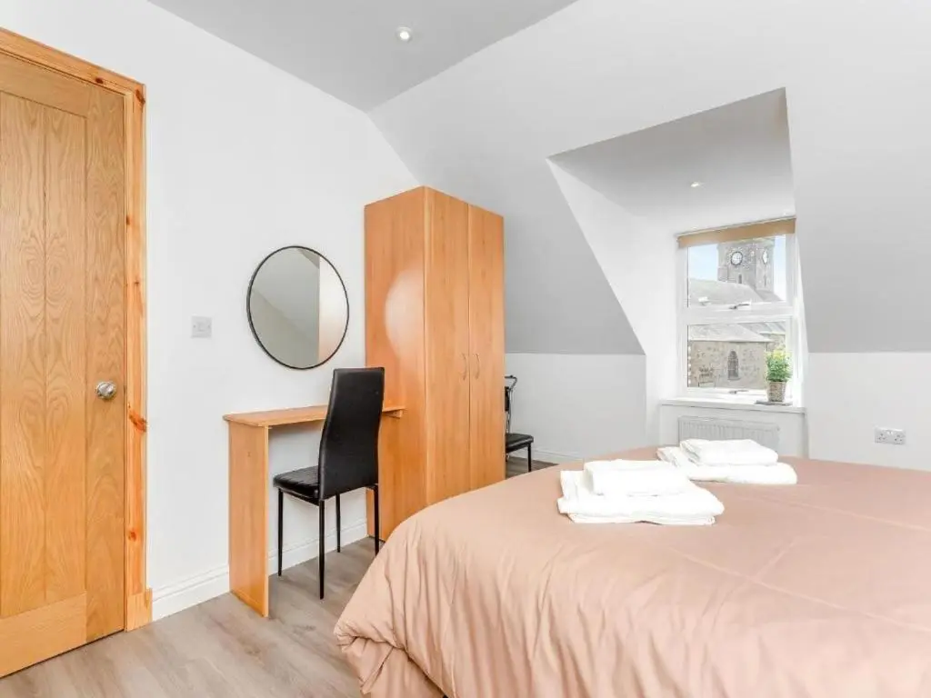 a bedroom with a bed with a desk and a mirror at Family - Central - Parking - Wifi - Sleeps 3 in Inverness