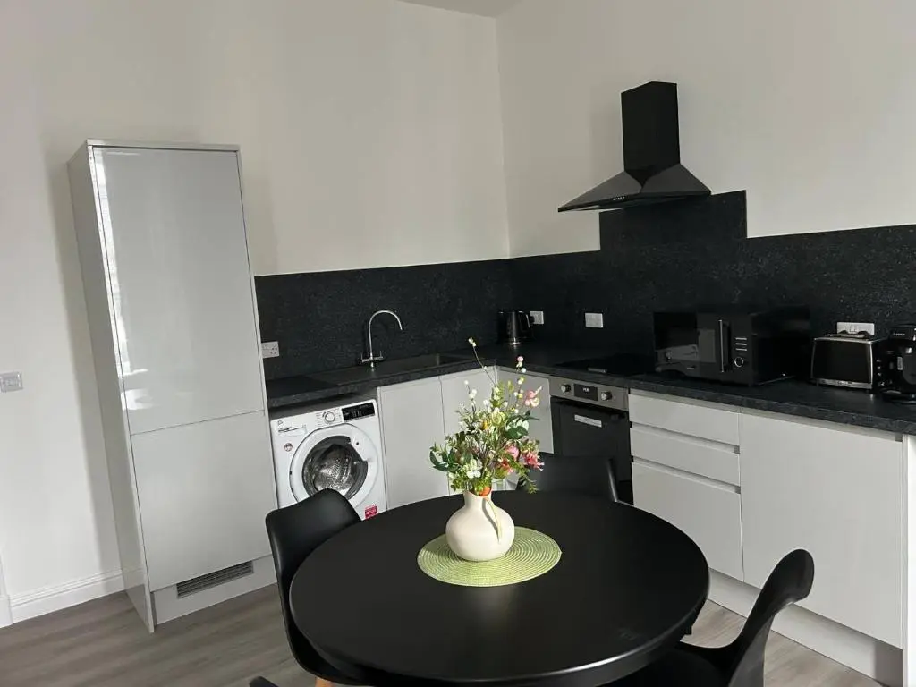 a kitchen with a table with a vase of flowers on it at Family - Parking - Central - Wifi - Sleeps 4 in Inverness