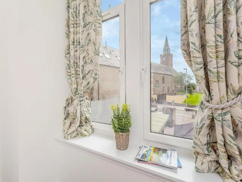 a window with a book and a plant on a window sill at Family - Central - Parking - Wifi - Sleeps 4 in Inverness
