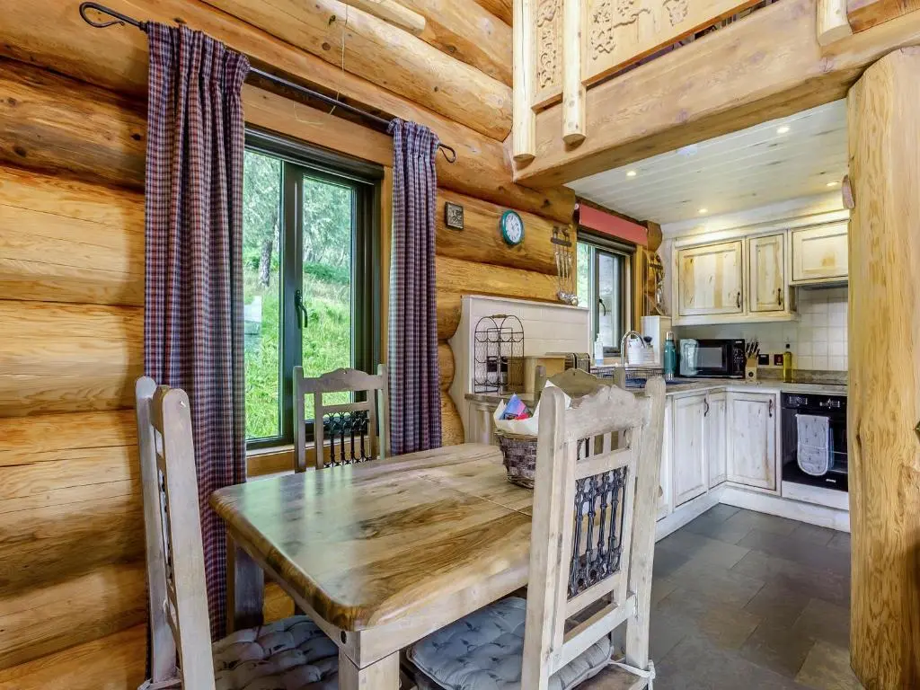 a dining room with a wooden table in a kitchen at Parus - Uk50083 in Beauly