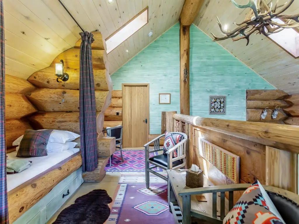a bedroom with a bed in a log cabin at Buteo - Uk50068 in Struy