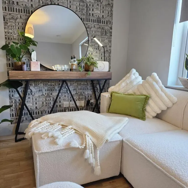 a living room with a couch and a mirror at Shamus cottage in Alness