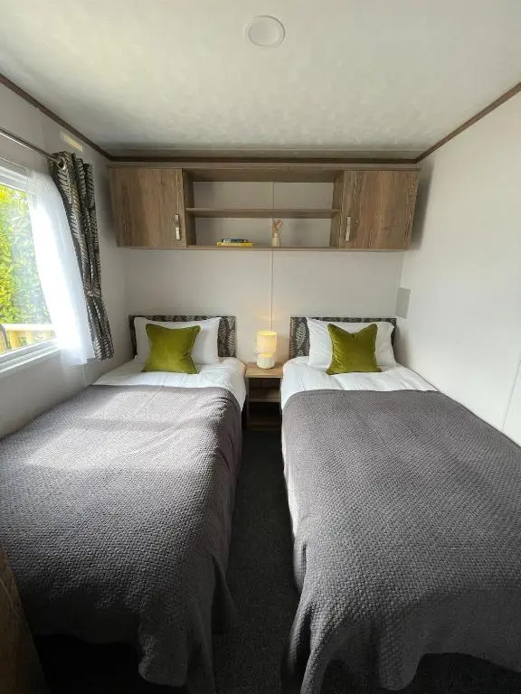 two beds in a small room with a window at Brand New Beautiful Home close to Inverness in North Kessock