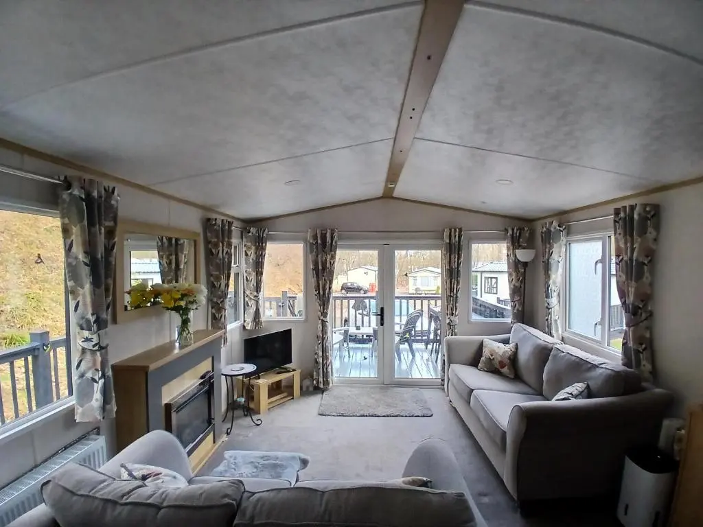 a living room with a couch and a tv at The Robin's Nest in Fochabers