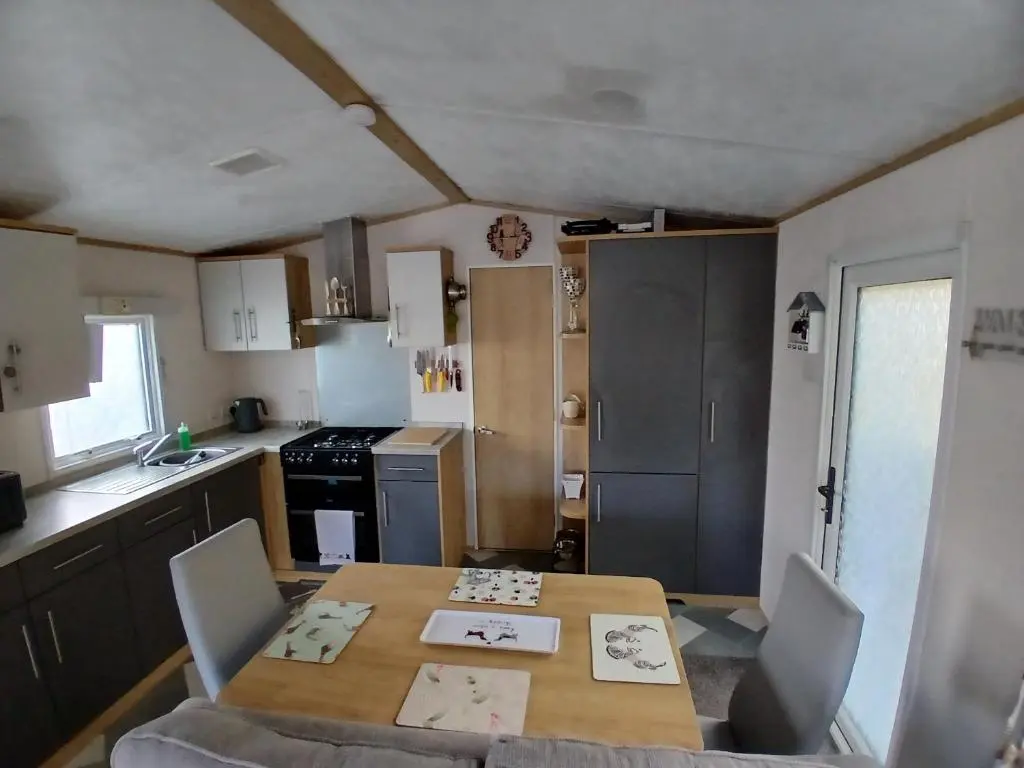 a kitchen with a table and chairs and a table and a kitchen at The Robin's Nest in Fochabers