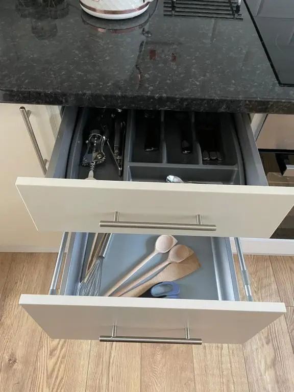 a drawer in a kitchen counter with some utensils at Millburn Court Apartment in Inverness