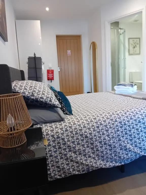 a bedroom with a bed with a blue and white comforter at The Snug on The Brae in Inshes