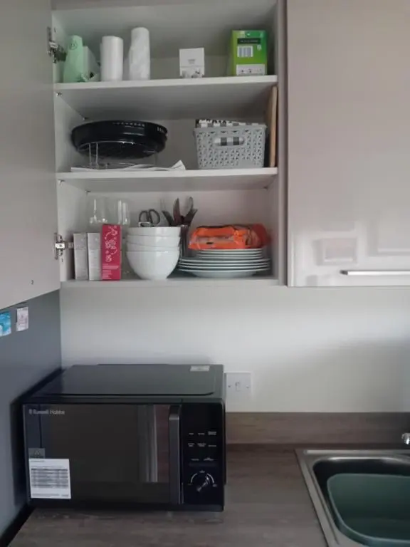 a microwave oven sitting inside of a kitchen at The Snug on The Brae in Inshes