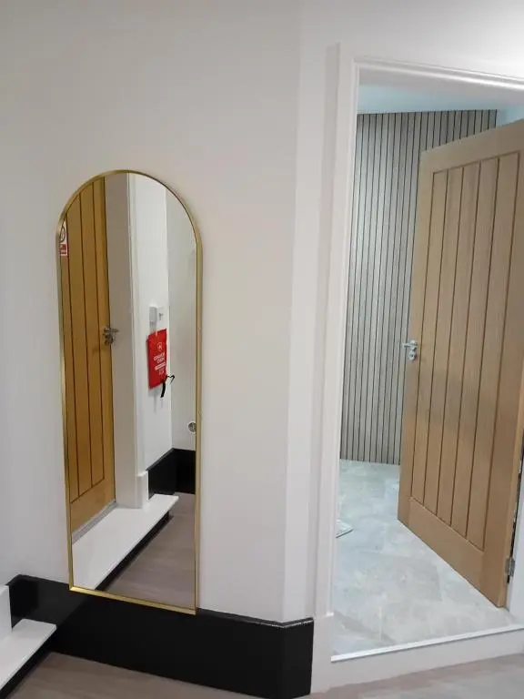 a mirror in a room with two doors at The Snug on The Brae in Inshes