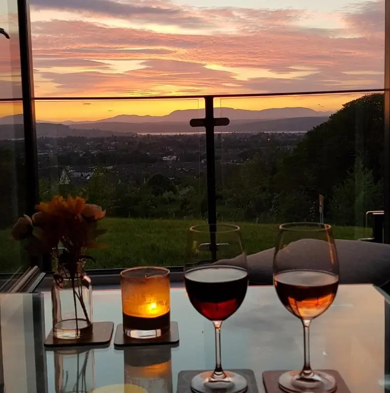 two glasses of wine sitting on a table with a view at Beinn View in Inverness