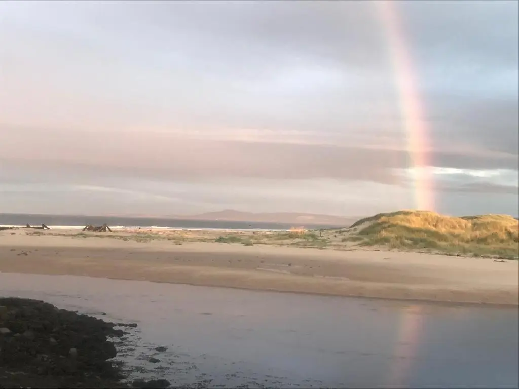 a rainbow in the sky over a beach at Moray Coast getaway in Lossiemouth
