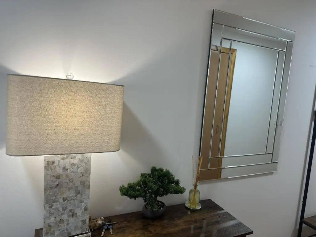 a lamp sitting on a table next to a mirror at LaScala Apartment in Inverness