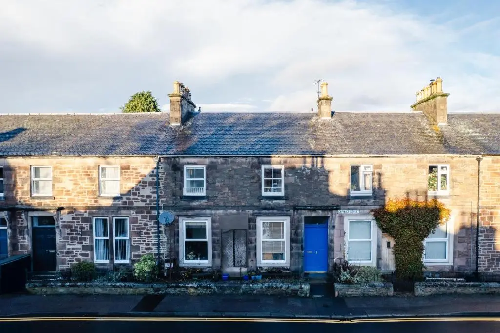 an old brick house with a blue door at Luxury New Inverness Apartment in a Prime Location in Inverness