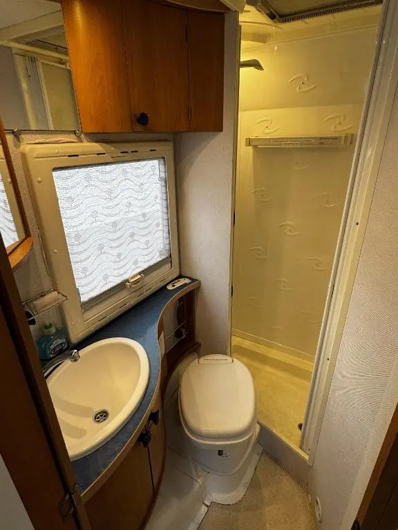 a small bathroom with a toilet and a sink at Rover Rentals in Inverness