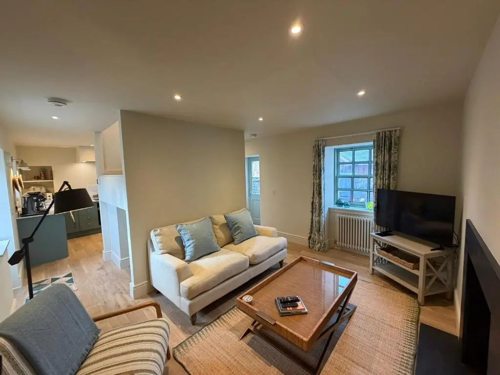 a living room with a couch and a tv at Gilchrist Square in Dornoch