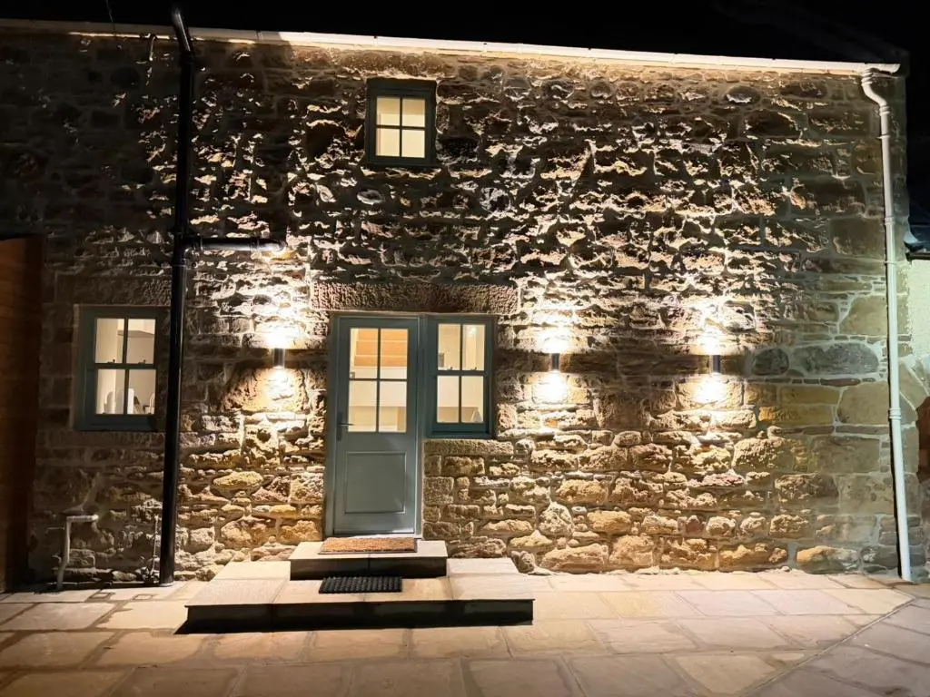 a stone building with a blue door and windows at Gilchrist Square in Dornoch
