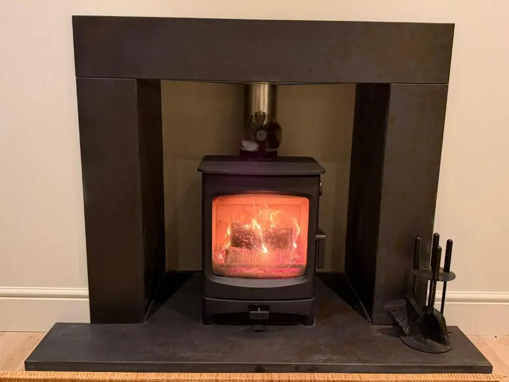 a stove with a fire in a room at Gilchrist Square in Dornoch