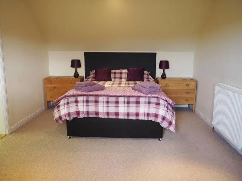 a bedroom with a large bed and two night stands at 3 Bed in Drybridge oc-w34891