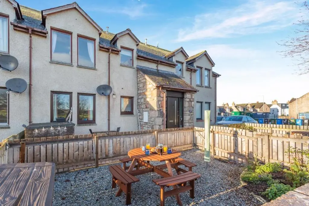 a house with a wooden fence and a wooden table at 2 Bed in Nairn oc-t34496 in Nairn