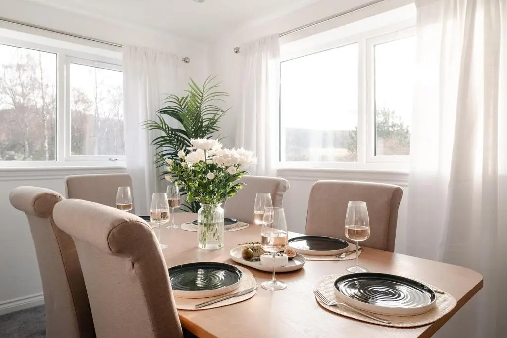 a dining room table with chairs and a table with wine glasses at Inshlea - Seasgair Lodges in Insh
