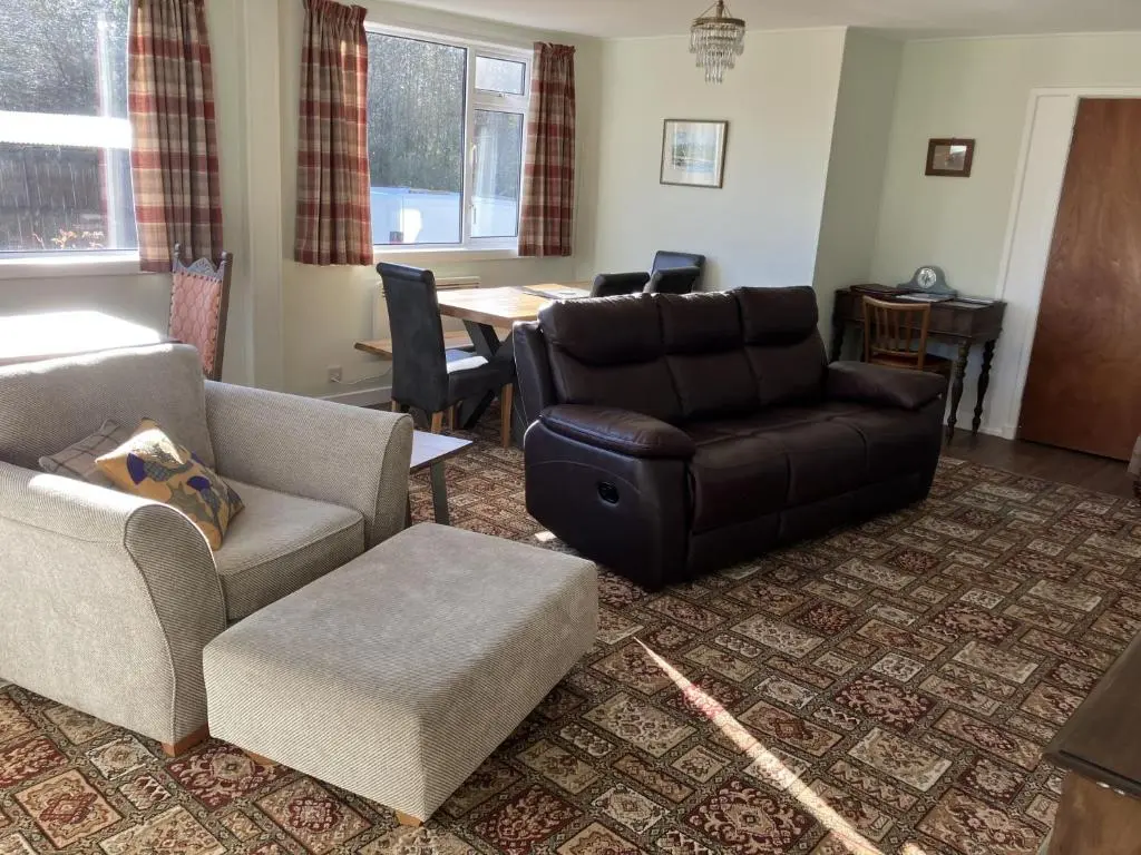 a living room with a couch and a chair and a table at Crianlarich Cottage in Fort Augustus