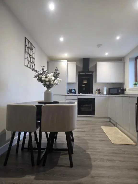 a kitchen with a table with a vase of flowers on it at Riverside View in Inverness